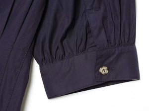 Détail du poignet bouffant avec bouton en résine et plis sur la robe bleu marine