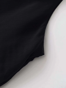 Macro shot of black chiffon fabric showing delicate texture and professional stitching