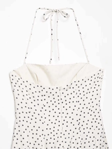 Détails de la fermeture éclair invisible au dos de cette robe à pois blanche et noire
