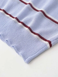 Detail of soft knit fabric with light blue, white and red stripes and ribbed hemline