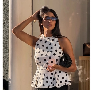 Détail du haut dos nu blanc à pois noirs en tissu tissé avec une texture riche