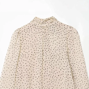 Chiffon polka dot blouse with high neck and ruffled shoulders in cream and black