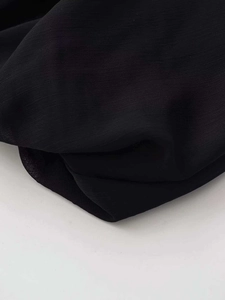 Detailed close-up of lightweight black chiffon fabric with a delicate woven texture