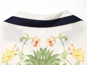 Detail of elegant tulip floral print on white pajama top with navy contrast piping