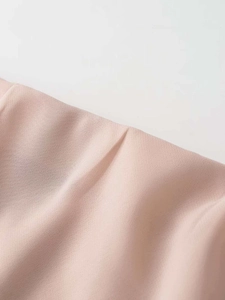 Gros plan détaillé sur la texture du tissu en mousseline plissée rose clair et soyeuse