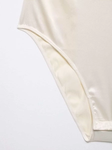 Detailed macro view of the double stitching on champagne satin fabric of this bodysuit