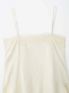 Close-up of beige silk camisole featuring delicate eyelash lace trim and adjustable straps