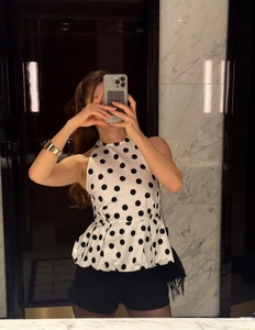 Haut chic à pois avec col licou et taille péplum sans manches en blanc et noir