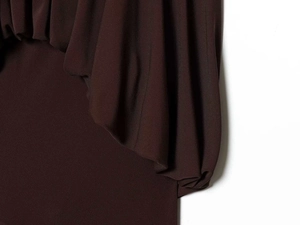 Detail view of deep brown elastic knit fabric showing texture and elegant draped folds