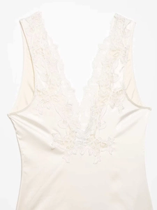Detail shot of the elegant floral lace neckline on a champagne satin bodysuit