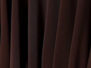 Macro shot of vertical pleated dark brown fabric showing fine texture and elasticity