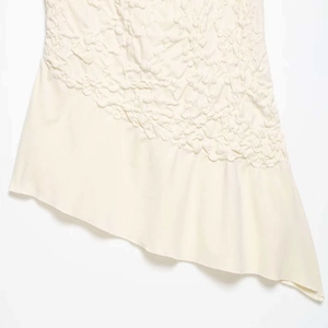 Off-white strapless top with embossed bubble texture and asymmetric hemline cut