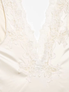Close-up of elegant cream satin bodysuit featuring delicate lace trim on V-neckline
