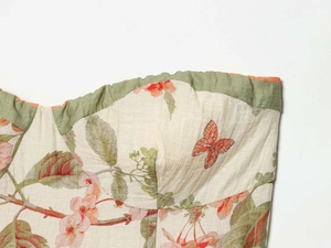 Detail view of cotton-linen floral dress with bow ribbon and butterfly patterns