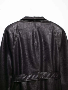 Detail of black pebbled leather jacket showing high collar and waist drawstring texture