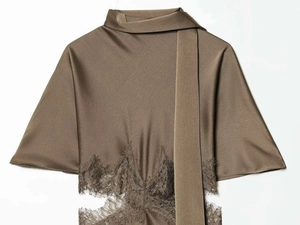 Detail view of bronze satin silk blouse featuring delicate eyelash lace trim and neck tie