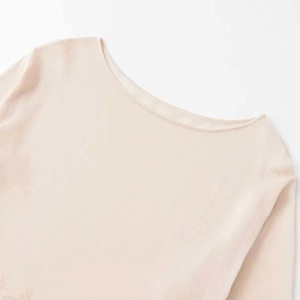 Elegant apricot knit top featuring a refined boat neck and soft premium fabric texture