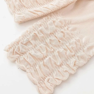 Apricot knitted top with elegant pleated hem and textured mesh details for women