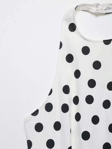 Détail du col licou avec boutons transparents sur le haut blanc à pois noirs