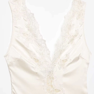 Elegant cream satin bodysuit with intricate floral lace embroidery and a deep V-neckline