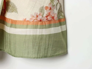 Close-up of linen floral dress featuring a colorful striped hem and detailed stitching