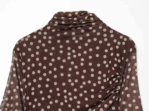 Detailed view of sheer mesh turtleneck top with vintage polka dots and ruched collar