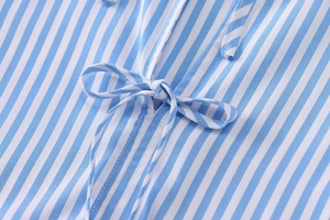 Close-up of blue and white striped poplin fabric with a decorative bow tie detail