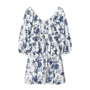 Détail des manches bouffantes et de l'imprimé floral bleu sur robe en coton blanc