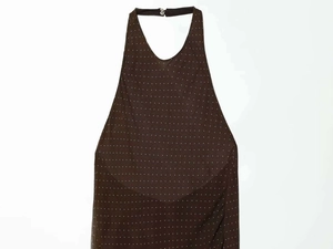 Detail of dark brown halter dress featuring white polka dot print and neckline closure
