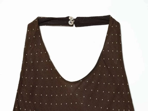 Detail of a brown polka dot halter dress neck with two white button fasteners