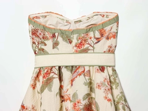 Detail view of floral tube dress featuring a heart neckline and green waist belt strap