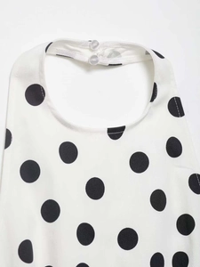 Détail du haut dos nu blanc à pois noirs avec fermeture à boutons au niveau du cou