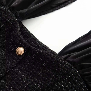 Detail of black tweed top with silver metallic fibers and an embossed gold metal button