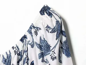 Vue détaillée du smock élastique et de l'imprimé floral bleu sur robe blanche