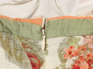 Close-up of floral print dress featuring invisible zipper and contrast color waistband