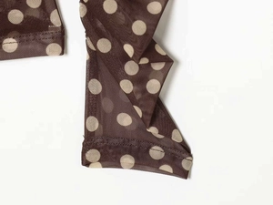 Detailed view of brown polka dot mesh fabric with double-needle hem stitching finish