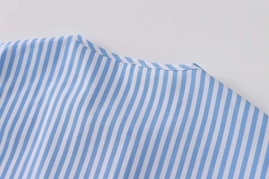 Detailed macro view showing the blue and white striped poplin fabric and collar stitching