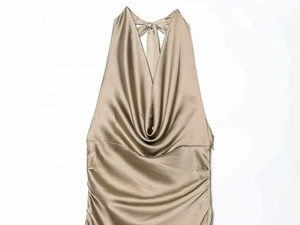 Close-up of champagne satin cowl neck dress with elegant ruching and halter neck detail