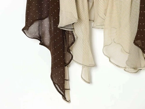 Close-up of asymmetrical dress hem with brown polka dot print and wavy pleated edges