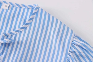 Detail of blue and white striped poplin shirt with S-size label and pleated neckline