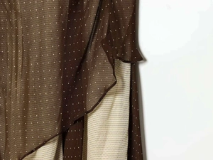 Detail of dark brown ruffled dress with white micro polka dots and layered chiffon fabric