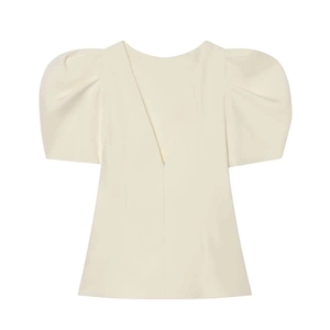 Detail view of cream puff sleeve top featuring back zipper and structured fabric texture