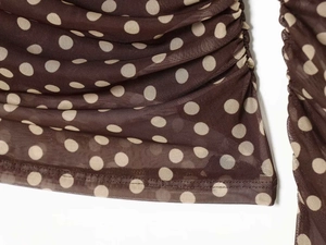 Detail view of brown polka dot sheer mesh fabric with elegant side ruching textures