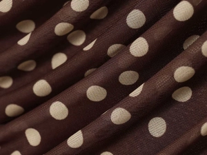 Macro detail of breathable dark brown polka dot fabric with soft mesh texture