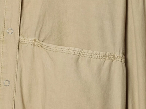 Dettaglio della giacca in popeline kaki con trama twill e chiusura con bottone a pressione