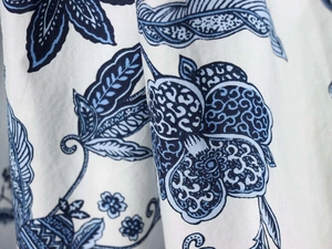 Gros plan sur l'imprimé floral bleu sur tissu en coton blanc pour robes d'été chic