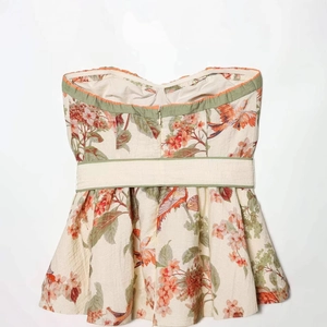 Women's floral strapless top featuring nature prints and elegant green trim accents