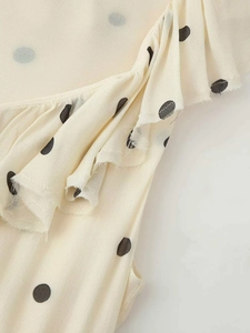 Gros plan d'une robe blanche à pois avec des détails à volants élégants et texture tissu