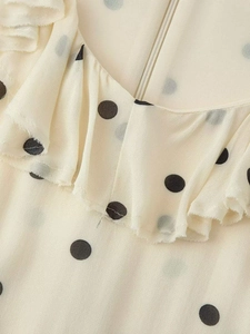 Détail de l'encolure d'une robe à pois avec volants et fermeture à glissière discrète