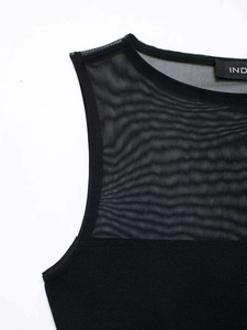 Detail of black sleeveless bodysuit with transparent mesh patchwork and round neckline